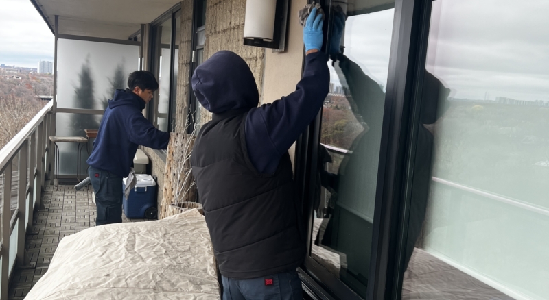 Interior balcony window cleaning in progress, with furniture safely covered to prevent any stains or damage