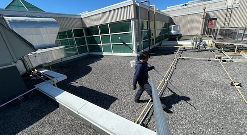 Tucker pole cleaning system used for industrial rooftop glass maintenance, reaching high windows without ladders