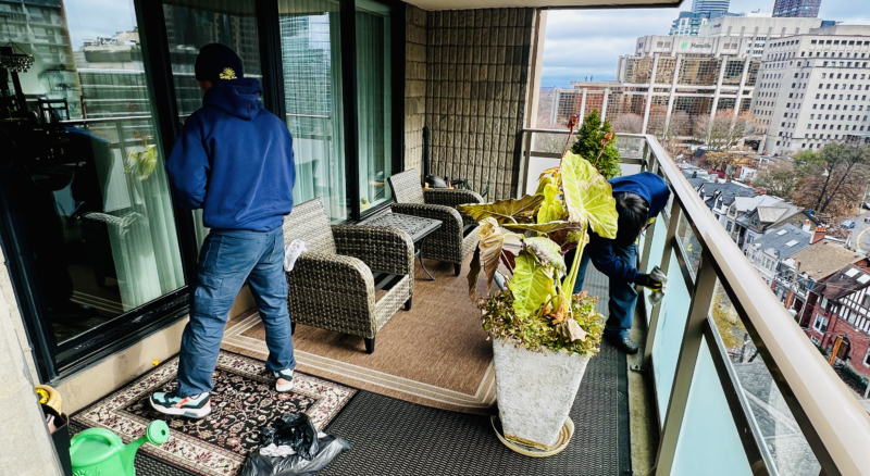 Worker cleaning the interior windows of a condo balcony, ensuring a streak-free finish.