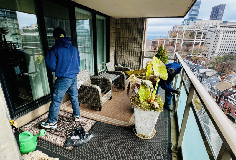 Worker cleaning the interior windows of a condo balcony, ensuring a streak-free finish.
