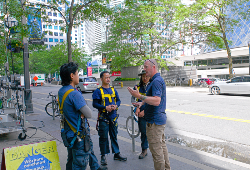Safety briefing during a toolbox talk, held before starting high-rise window cleaning work on a swing stage