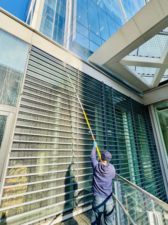 Extended pressure washing service, using a long wand to clean hard-to-reach areas of a building’s exterior