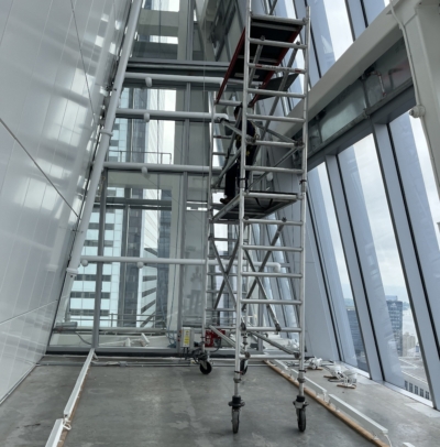 Altrex two-tier scaffold being used to clean interior windows of a commercial building
